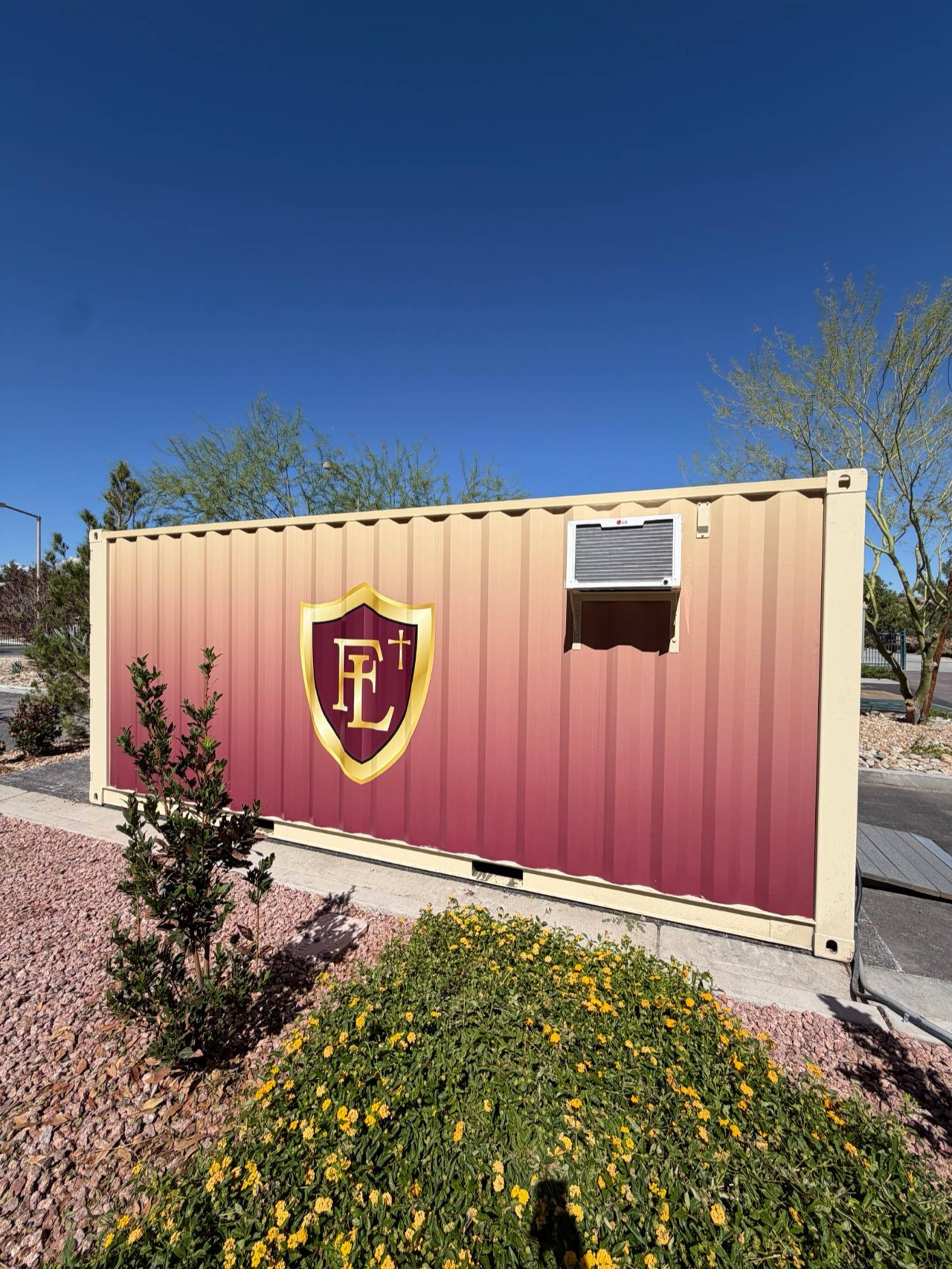 Faith Lutheran shipping-container wrap — Full gradient wrap with the school crest on a 20 ft corrugated storage container, around the AC unit — Las Vegas, NV