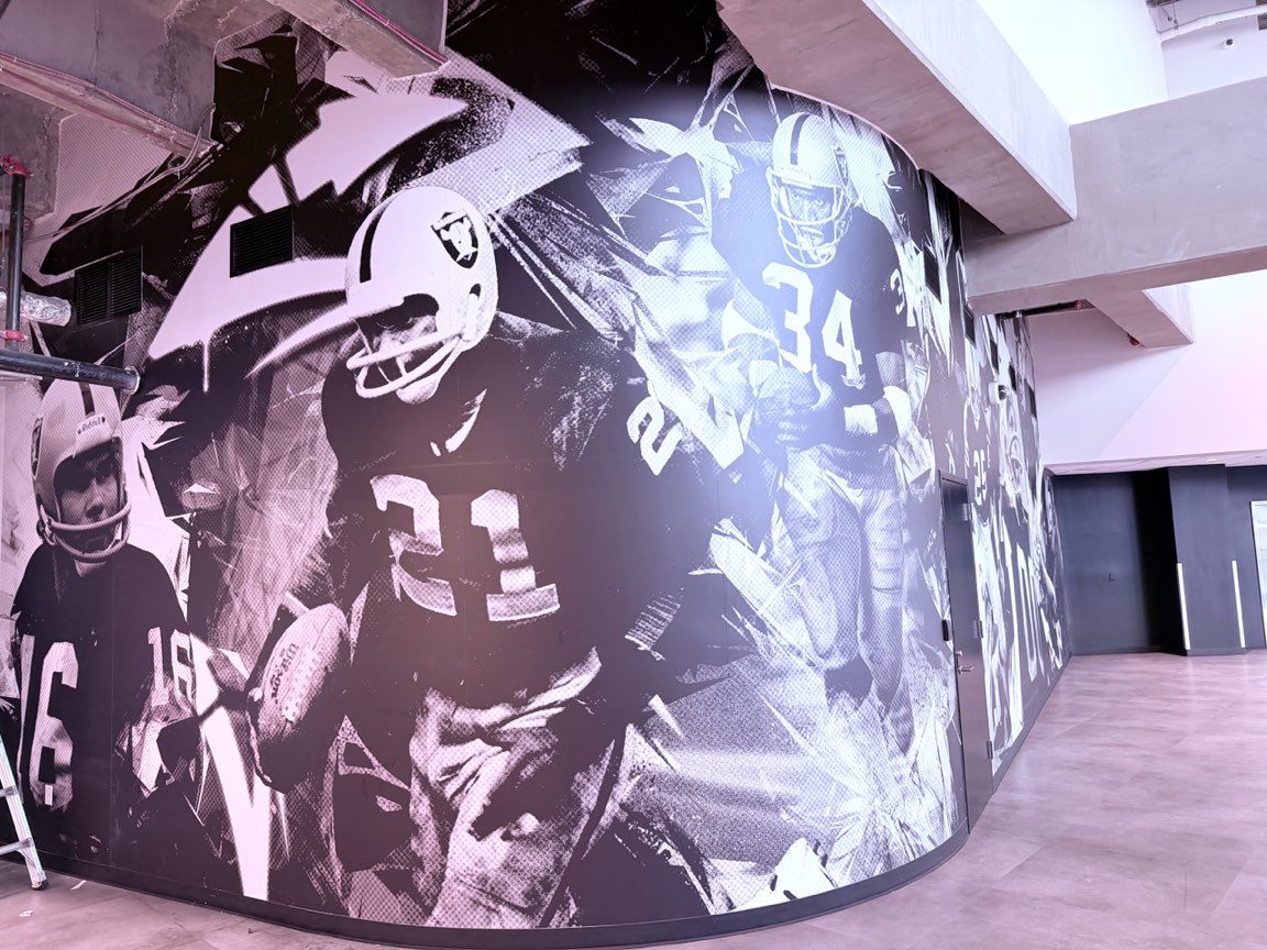 Black and white Raiders legends mural installed on a curved stadium wall